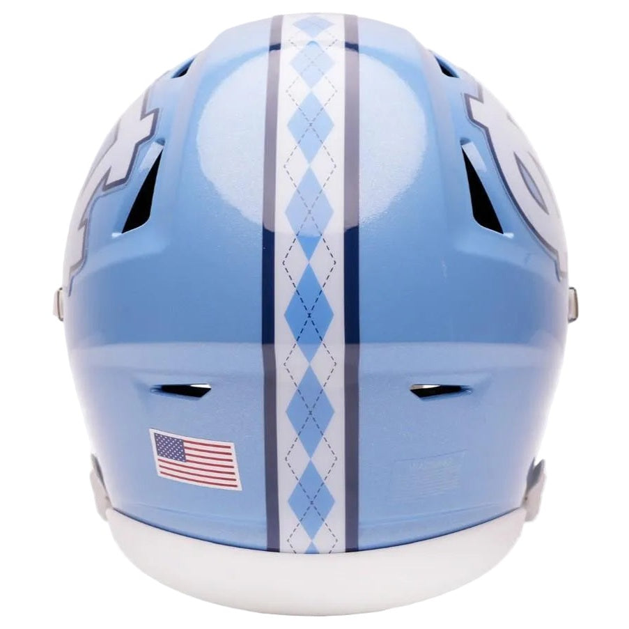 A light blue football helmet featuring a vertical argyle pattern in light blue, white, and dark blue down the center, with a small American flag sticker on the lower left side.